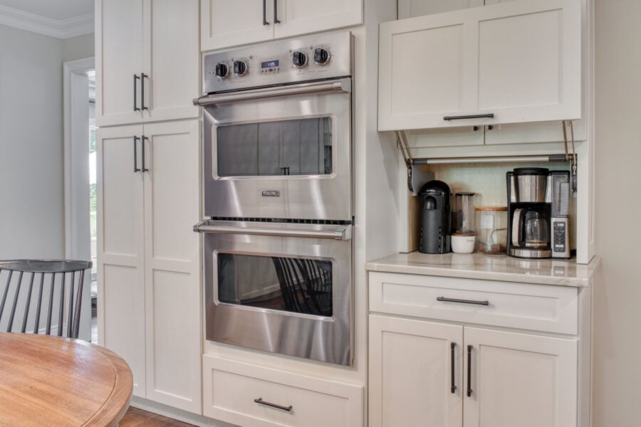 Built-in appliance garage with a lift-up cabinet door housing a coffee maker and countertop appliances.